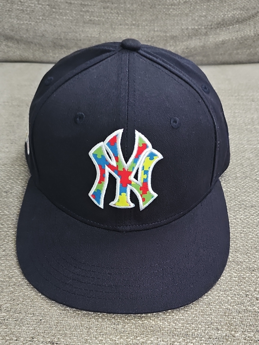 Navy Yankees Baseball Cap with Autism Awareness Ribbon & Multicolor Puzzle Logo